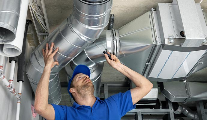 a professional performing maintenance on an air duct